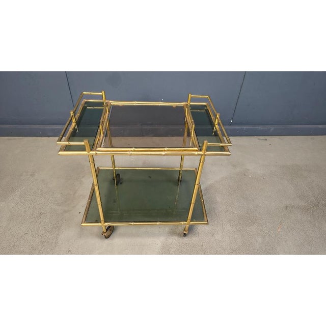 Elegant mid century faux bamboo brass serving trolley with smoked glass. 1960s- Italy Good condition Dimensions: Height:...