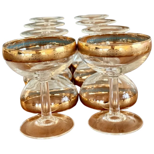 Elegant set of eight vintage champagne coupes marked France, distinguished by luminous clear bowls accented with rich gold...