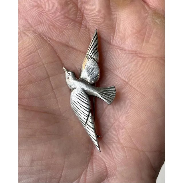 A stylized pin brooch in the shape of a dove. A classic symbol of love and peace. It is executed in 925/1000 sterling...