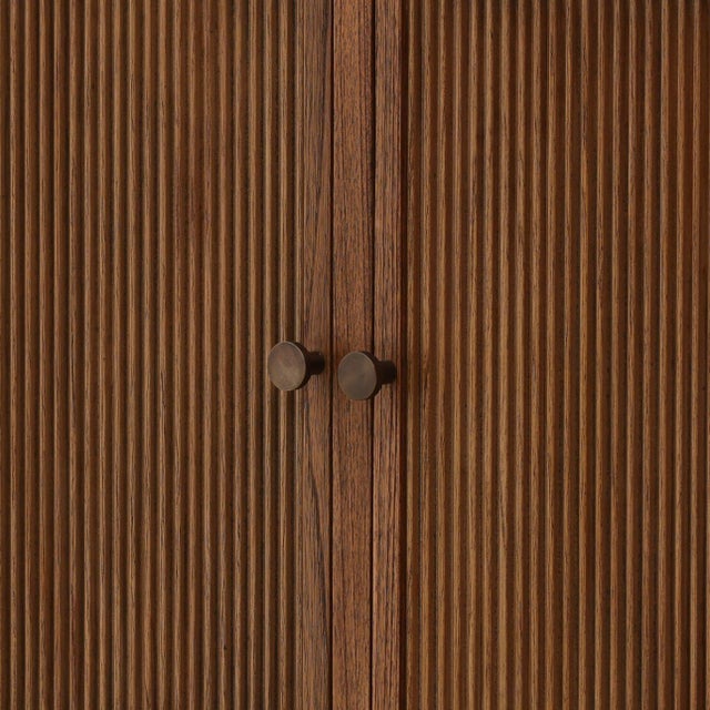 Beautiful warm brown Mindi wood sideboard with carved turned leg design and four doors with vertical reeded texture. Doors...