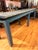 An impressive industrial work table covered in a weathered blue-grey painted base and a durable galvanized metal top. Its...
