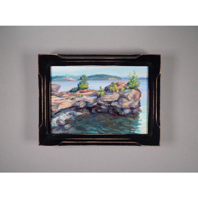 This oil painting captures a serene coastal scene, featuring rugged rock formations adorned with clusters of vibrant...