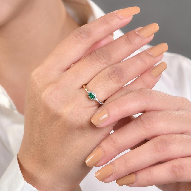 Contemporary Pear-Cut Emerald Diamond Wedding Ring in 18K Gold featuring natural emerald of 0.27 carats and diamonds of...