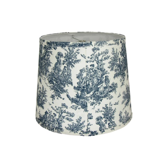 This navy toile drum lamp shade features a classic pastoral design in deep navy tones on a crisp white background,...