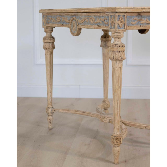 A charming Swedish Gustavian console table dating to circa 1860, featuring beautifully carved neoclassical decoration and...
