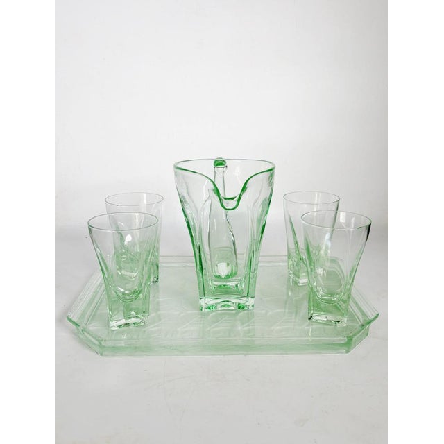 Glassware set, France, 1940s, comprising a tray, a carafe, and four matching glasses. Made of slightly green-tinted glass,...