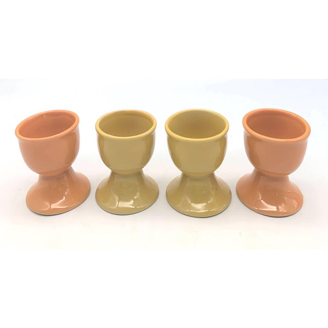 Offered is a set of 4 vintage ceramic egg cups, 2 that are yellow, and 2 orange. The egg cups each measure 2" in diameter...