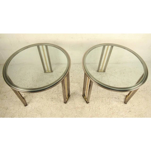 Hollywood Regency style tables with polished metal frames and round beveled glass tops. Elegant design for your modern...