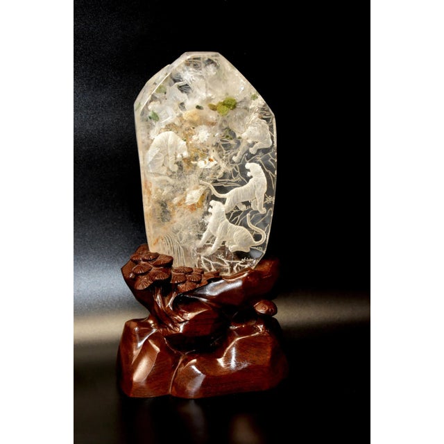 A magnificent and rare hand-carved sculpture, depicting five tigers roaming through a forest. This exceptional piece is...