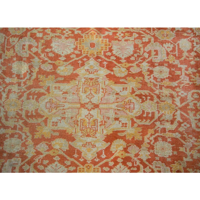 A stunning late 19th century Turkish Oushak rug with a large floral and scrolling vine medallion living amidst a field of...
