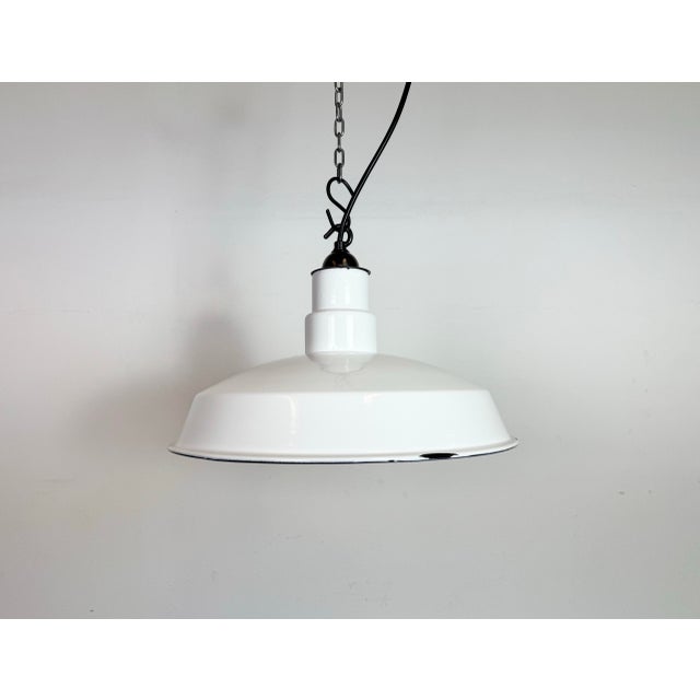Industrial white enamel factory pendant light made in United States during the 1960s. White enamel inside the shade. Brass...