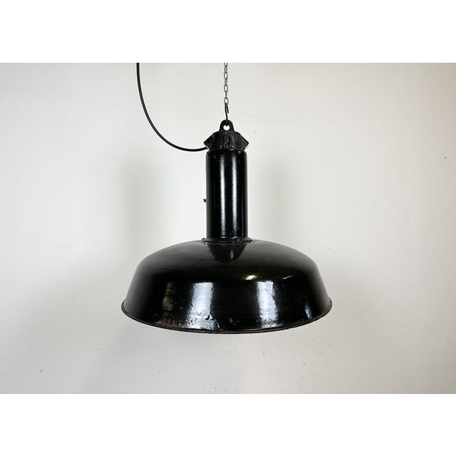 Industrial black enamel pendant light made in former Czechoslovakia during the 1960s. White enamel inside the shade. Cast...
