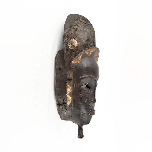 The Baule portrait mask discussed is intricately crafted for the Mblo dance, representing an honored person or ancestor in...