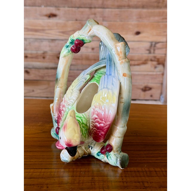 A charming vintage Japanese ceramic wall pocket featuring a colorful tropical parrot perched within a faux bamboo arch...