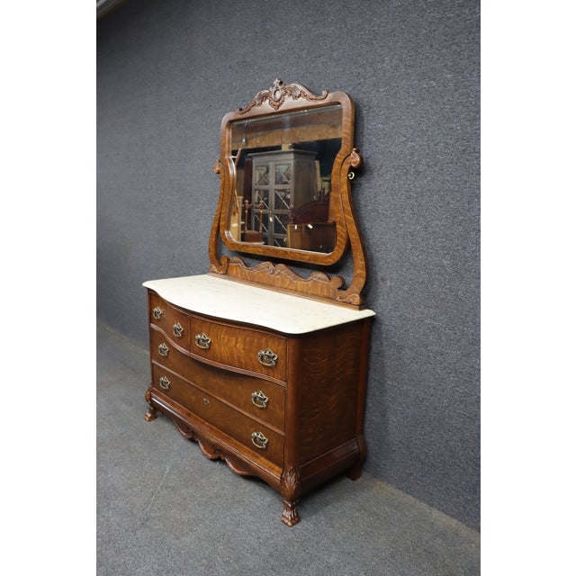 Pulaski Furniture Victorian Revival oak dresser with attached carved mirror and faux marble top. The dresser features...