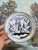 This likely antique ceramic dish features a hand-painted blue and white botanical motif rendered in fluid brushwork,...