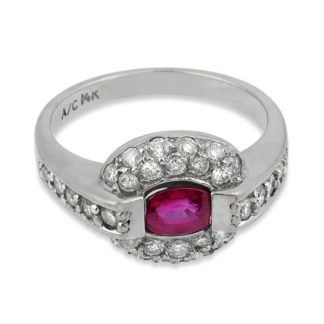 A graceful jewel from the Mid Century era, this elegant ring centers on a vibrant oval cut ruby weighing approximately...
