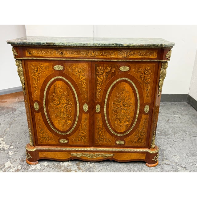 Design Plus Gallery presents a Vintage Louis XVI Style Marquetry Cabinet. This ornate cabinet showcases intricate floral...
