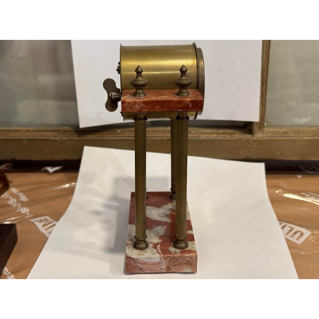 This is a 1900s vintage French portico clock decor. It has a red marble base and pillars with bronze mounts. The clock...