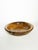 A beautiful artisanal bowl turned from a single piece of solid wood, showcasing stunning natural grain with warm shades of...