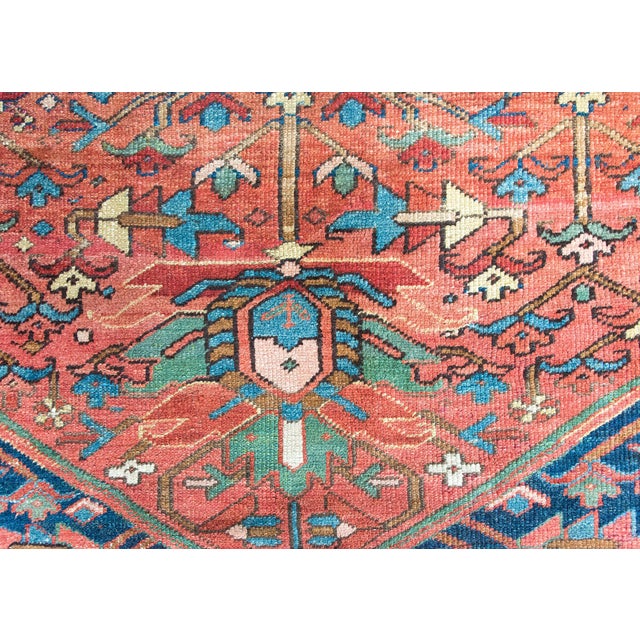 A wonderful early 20th century Persian Heriz rug with a primitive stylized floral pattern in the center listing amidst a...