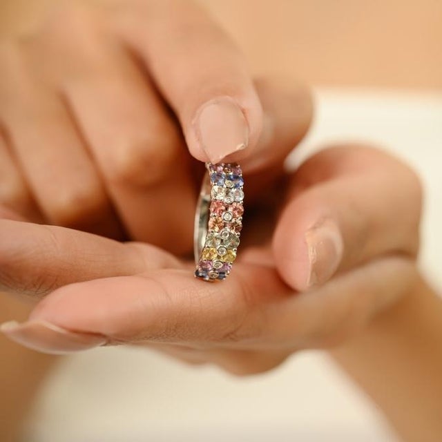 This modern half band ring features 20 round cut multi sapphires totaling 1.62 carats, set in 18k white gold. Each...