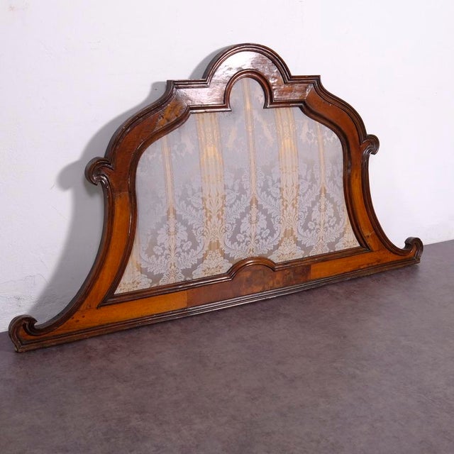 Antique wooden headboard from the second half of the 19th century upholstered on the front with elegant damask fabric. The...