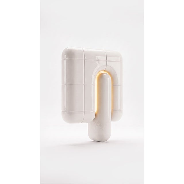 The smallest lamp in the collection, and often the first one people reach for. Its folded form hides the source entirely,...