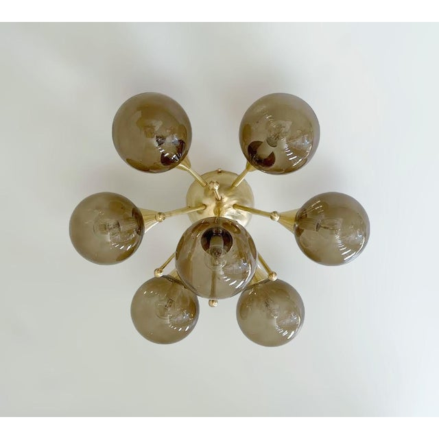 Italian flush mount with seven smoky Murano glass globes mounted on solid brass frame in unlacquered natural brass finish...