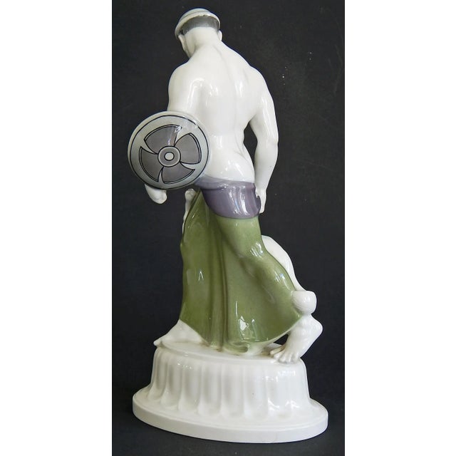 An extraordinary, rare and historic porcelain sculpture, this depiction of a half-nude Goth with a greyhound by his side...