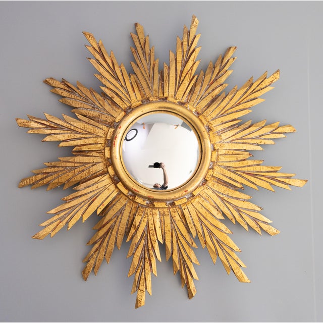 A beautifully carved French giltwood sunburst mirror with the original convex glass, circa 1950. The lovely gilt patina...