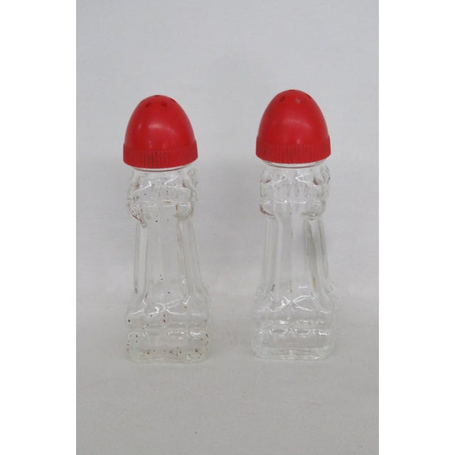 This beautiful Pair of Salt and Pepper Shakers is made of glass with plastic lids. Both Shakers in this lovely set present...