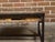 A contemporary coffee table made from an antique wooden fragment door with raised motifs under glass and mounted on a...
