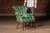 Art Deco influenced lounge or club chair featuring a dramatic fan-form shell back upholstered in deep green vinyl with...