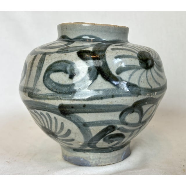 This beautiful vase depicts blue pinwheels and curved lines.