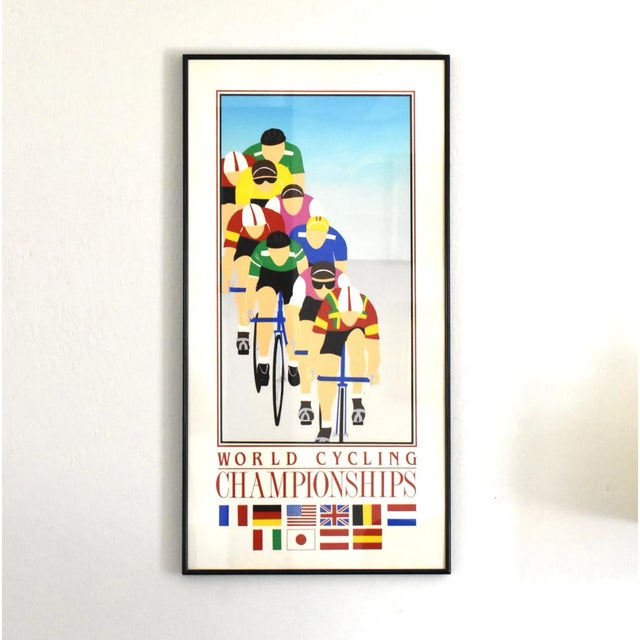 A vintage framed World Cycling Championships poster by Phil Dynan, featuring a stylized graphic illustration of colorful...