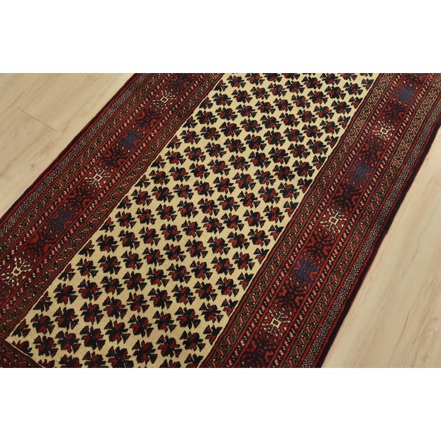 An authentic vintage tribal Baloch rug hand-knotted with fine wool and natural dyes. This nomadic rug features an all-over...