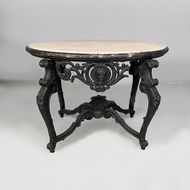 Italian coffee table in black wood and marble, late 1800s. Coffee table with oval light marble top. The frame in black...