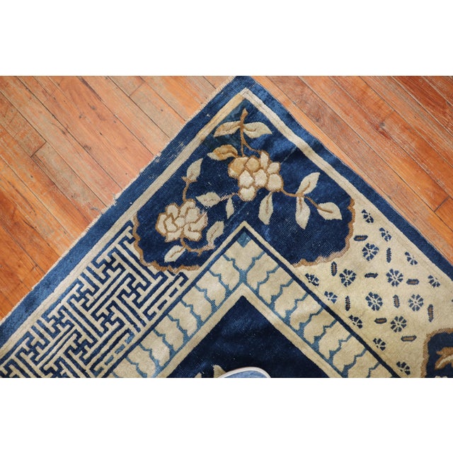 A rare 11-foot square early 20th-century shabby chic weather textured Chinese rug with a graphic floral Motif in denim...