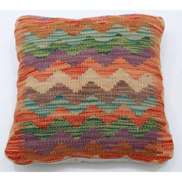 A one-of-a-kind handwoven Afghan wool kilim accent pillow featuring zigzag chevron stripes in green and orange. Cut and...