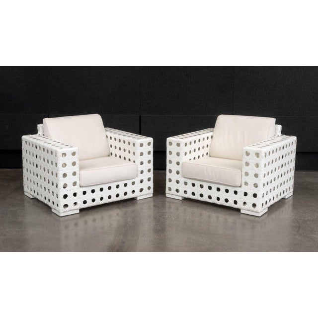 Pair of Skyline Design Lounge Chairs, with white woven plastic frames and beige cushions. 36" H x 42" W x 36" D; seat:...
