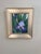 This oil painting captures the delicate beauty of an iris, its soft lavender petals contrasting with the lush green leaves...