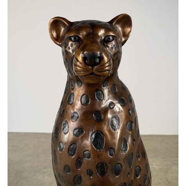 A large-scale bronze cheetah sculpture, captured in a poised seated position. Elegant and commanding, this piece balances...