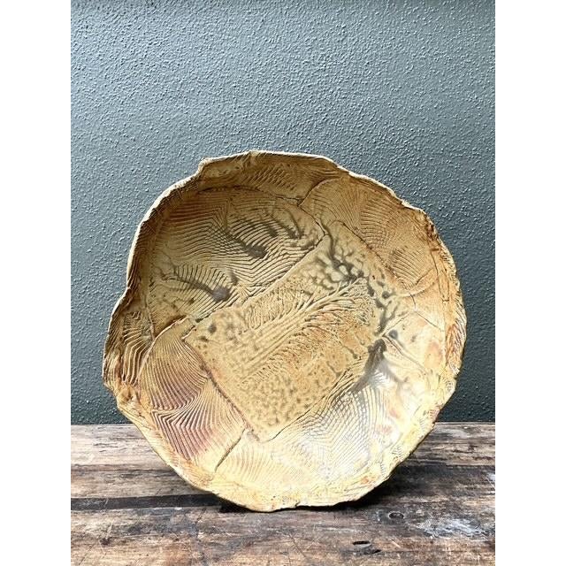 This striking studio pottery platter is a masterwork of organic form and textural exploration, prominently signed by the...