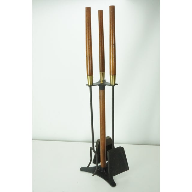 Vintage Mid-Century Modern fireplace tool set featuring long straight wood handles, brass-tone collars, and black...