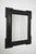 Carved ebonised wooden mirror, XIXth c. Reverse profile mirror carved ebonised wood mirror. Italy, 19th c. Height: 101 cm...