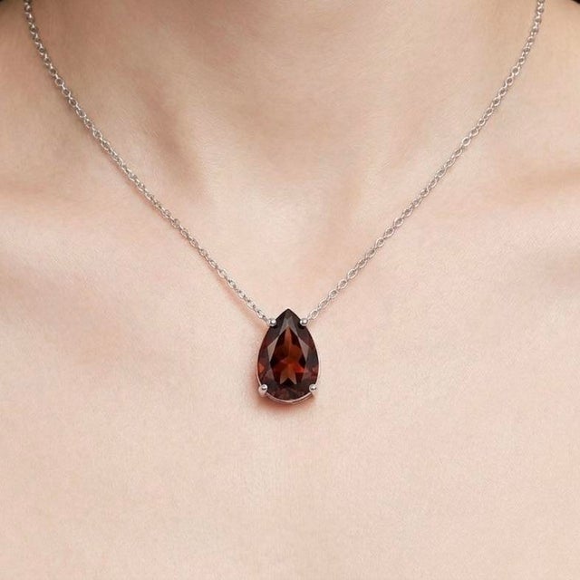 Timeless and elegant, this refined necklace features a striking solitaire gemstone that radiates rich color and classic...