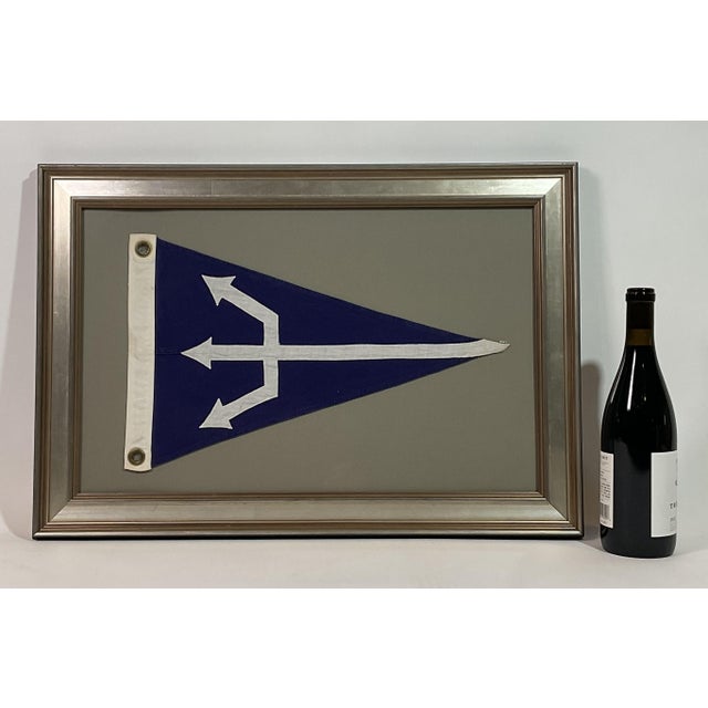 Linen flag with a large white trident spear stitched onto a blue field, white hoist with brass grommets. Set into a frame...