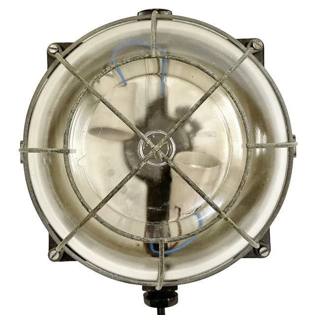 Vintage industrial bakelite wall lamp made in former Czechoslovakia during the 1970s. It features a bakelite body, a clear...