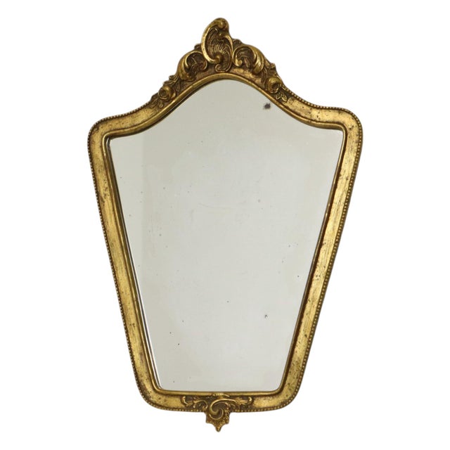 Small vintage crest mirror in classic Baroque style, made of resin gilded with gold leaf; manufactured in France during...